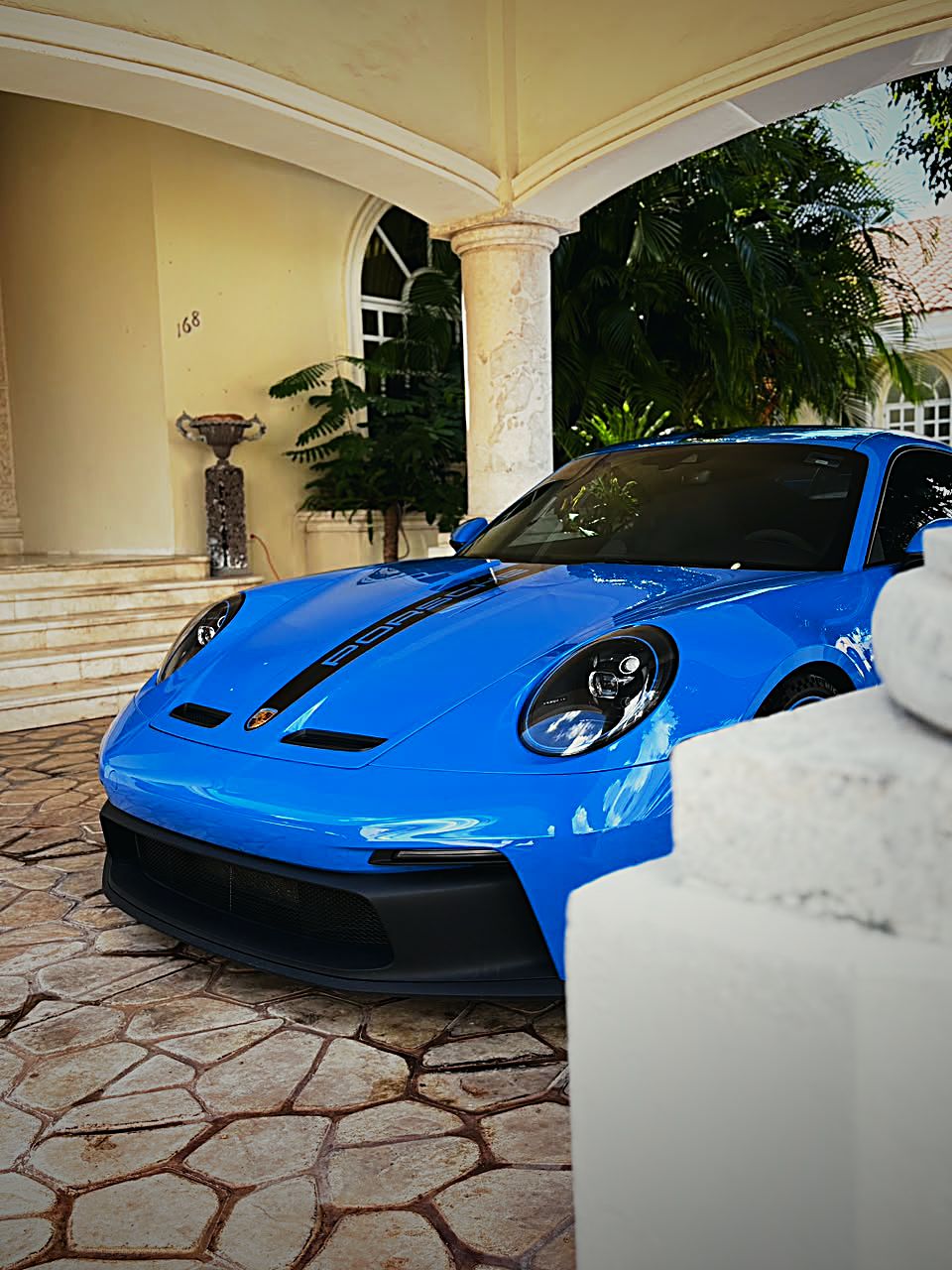 Porsche 911 GT3 azul frente a la entrada de una casa